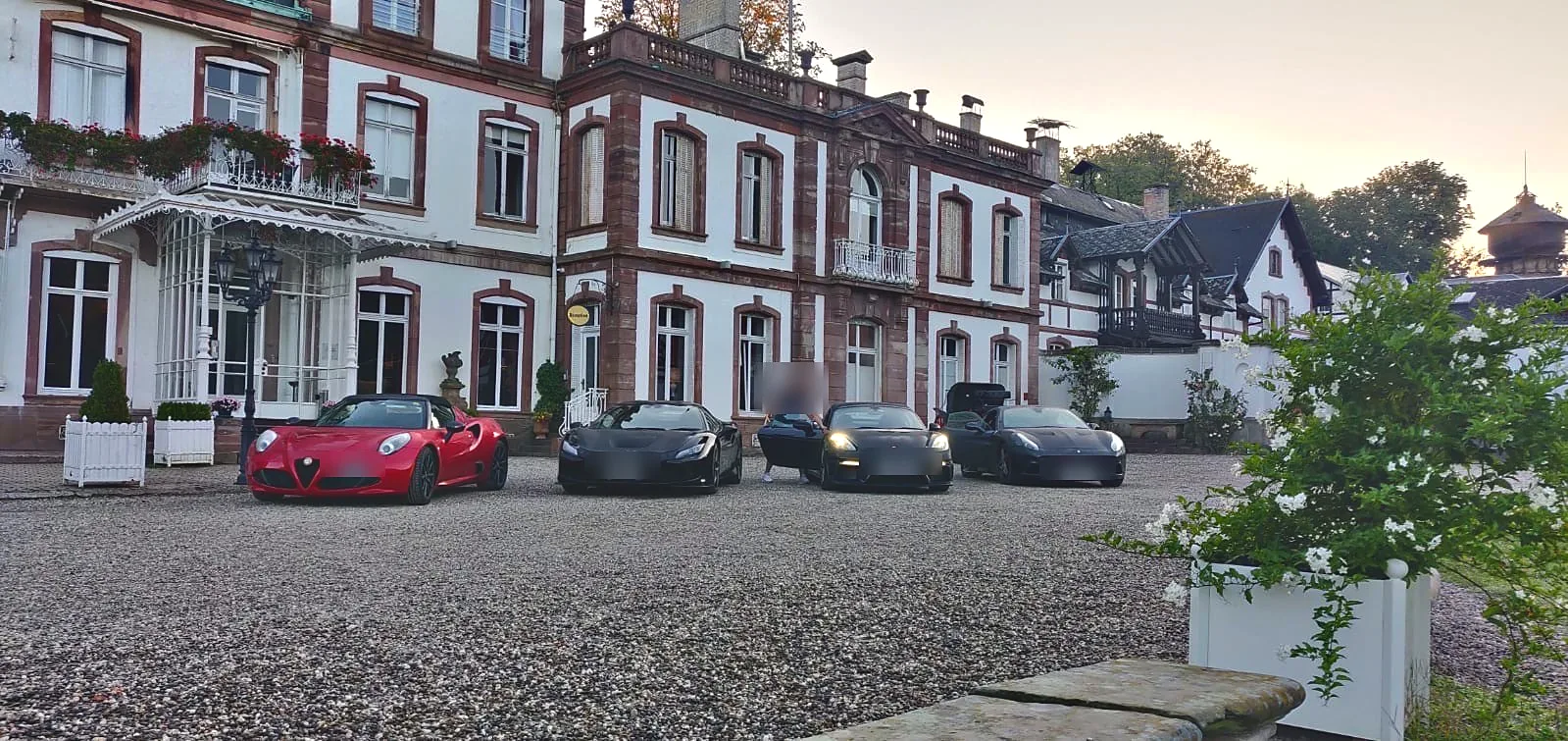 Sports cars parked outside a château hotel